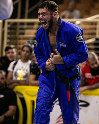 A jiu-jitsu competitor in a blue gi at an IBJJF tournament